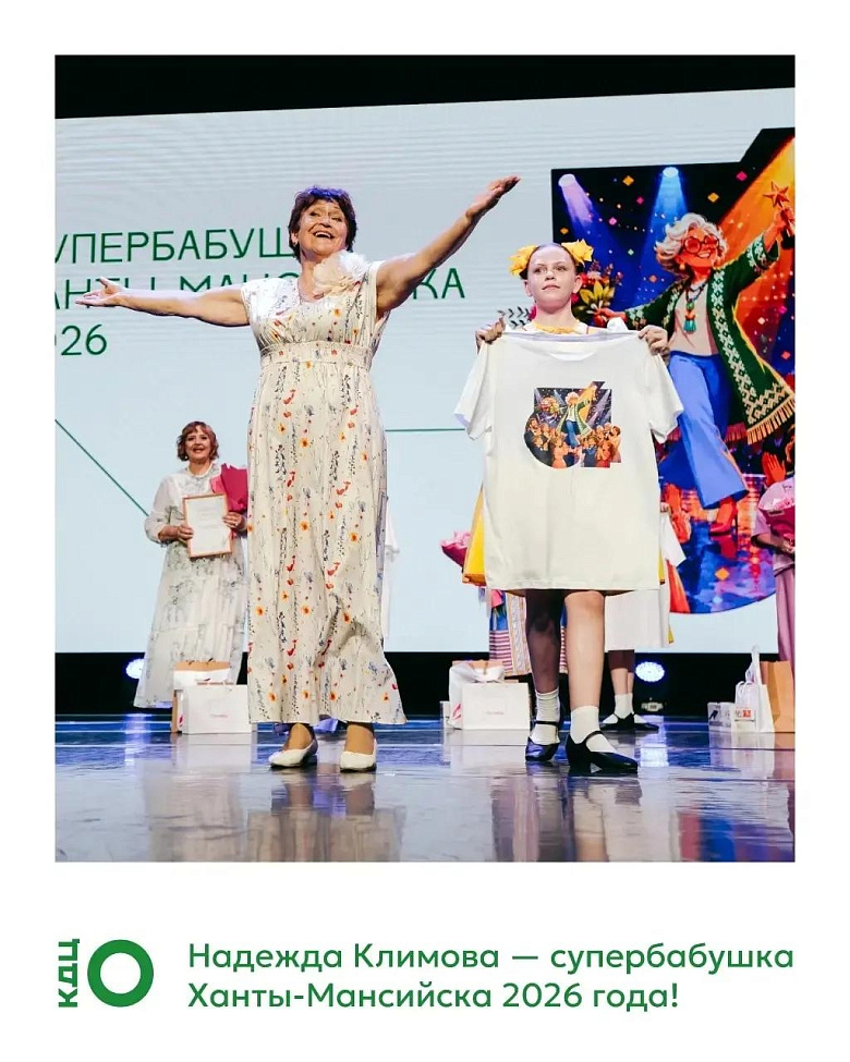 На сцене — женщина в светлом платье с цветочным узором, раскинув руки, улыбается. Рядом девушка держит белую футболку с принтом. Позади — ещё одна участница, а также декорация с изображением бабушки на фоне сцены. Внизу подпись: «Надежда Климова — суперба
